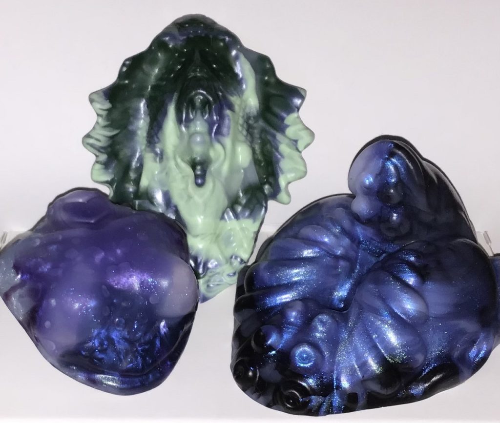 Ris, a bust with small breasts, is a marble of translucent, purple, and blue. Calypso, a vulva with fins on either side, is a marble of translucent dark green, silver, and light green. Pelagio, a tentacle t-dick/vulva, is a marble of translucent, black, and shimmery blue.